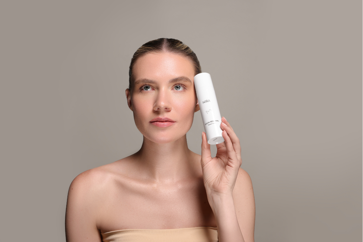 Model holding the NIRA Skin Youth Renewal Peptide Cream, showcasing a hydrating and anti-aging skincare product.