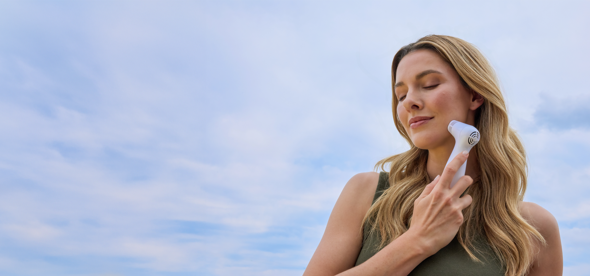 Woman enjoying an at-home laser facial using a skin-tightening laser for face care.