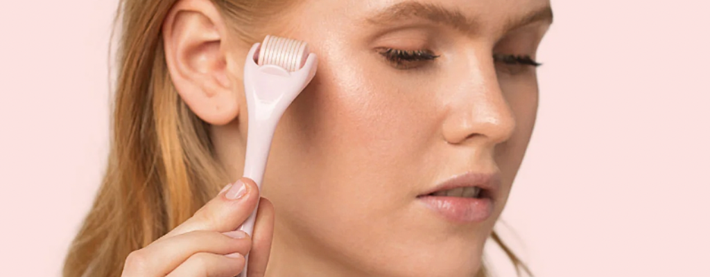 Woman using an at-home microneedling device to stimulate collagen production
