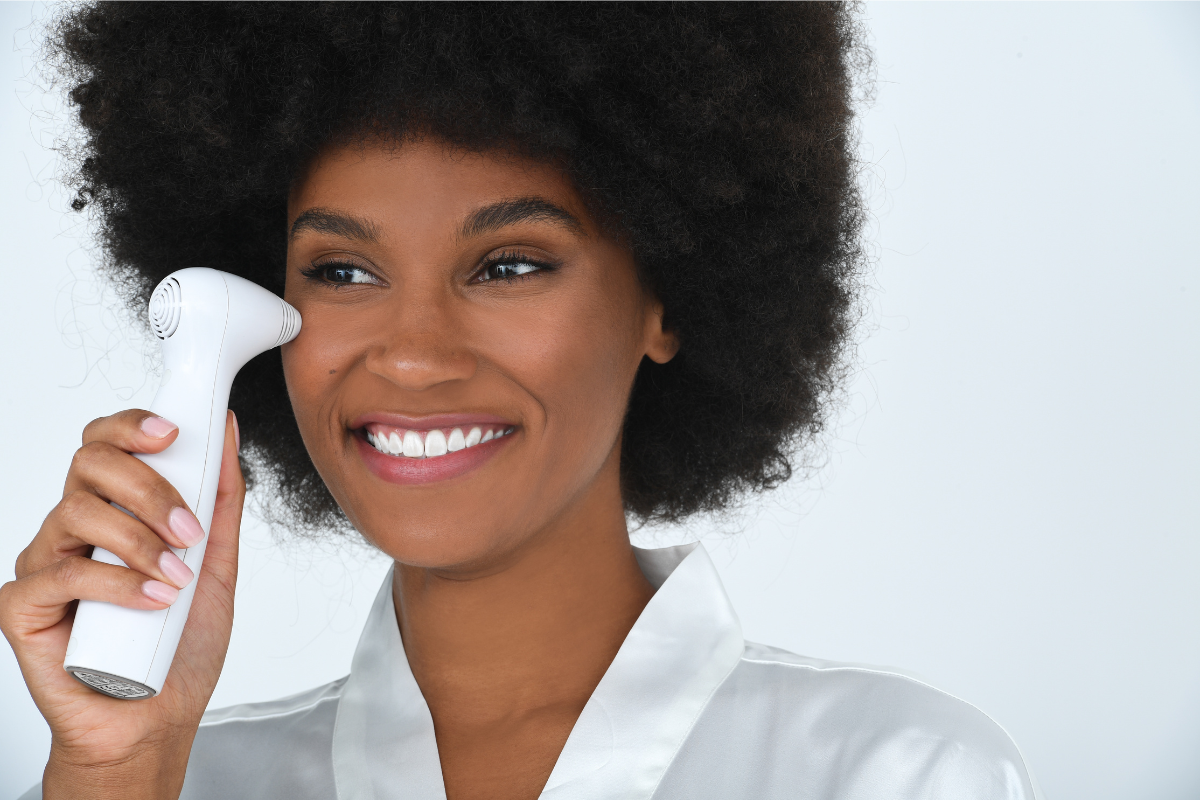 Model using the NIRA Precision at-home laser under her eye to reduce fine lines and wrinkles.