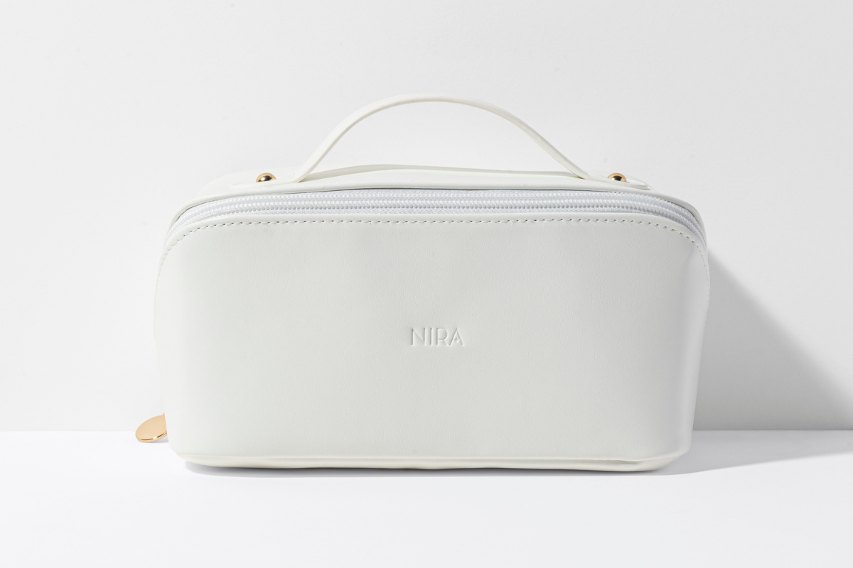 Travel case with NIRA Skincare products sitting on a bathroom counter, ready for at-home laser skincare on the go.