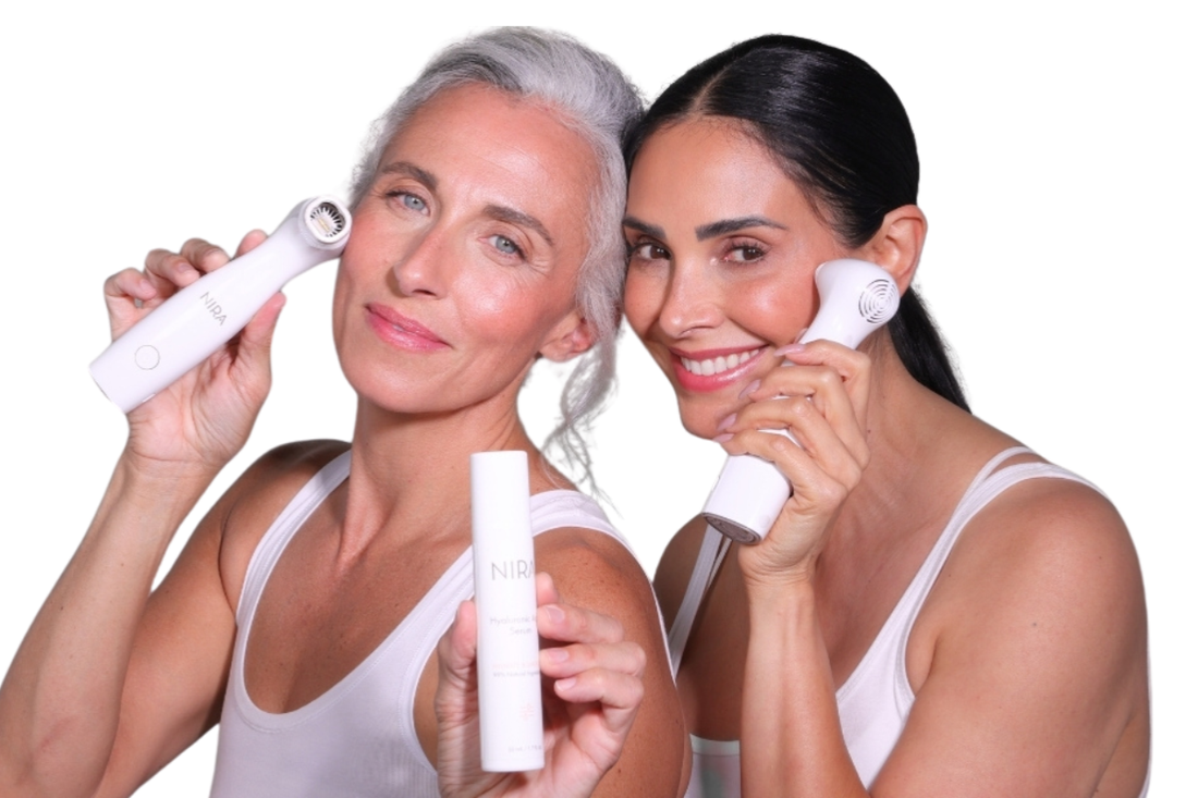 Two women smiling and showing radiant, youthful skin while holding NIRA Skincare at-home laser devices for wrinkle reduction, collagen-boosting, and skin tightening.
