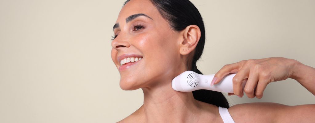 Woman using the NIRA Pro at-home laser to tighten skin under her chin