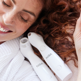 White nira facial cleansing devices with sleek, ergonomic design and smooth matte finish