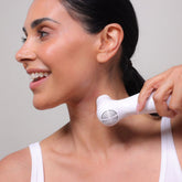 Woman using the NIRA Pro 3 Laser - Early Access device on her neck for skincare and wrinkle reduction.