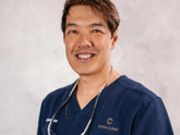 Dermatologist smiling with blue scrubs