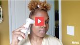 White handheld facial device with a red play button overlay