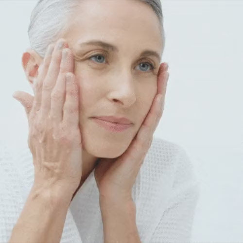Woman patting her freshly cleansed face with both hands before a NIRA Precision laser treatment