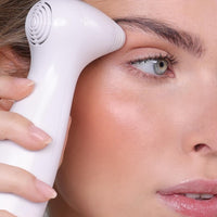 Woman with glowing skin uses the NIRA Precision Laser on her hooded eyes
